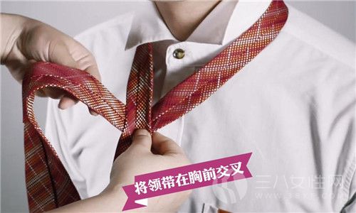 第一步：准备一条领带，然后围绕在衬衣领外，把领带在胸前交叉。