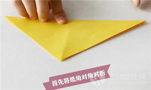 第一步：我们应该先把折纸进行角对角对折。
