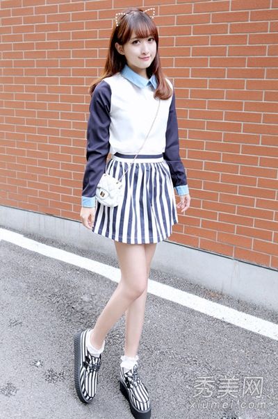 短裙女孩在秋天穿长袖上衣和短裙显得很高。