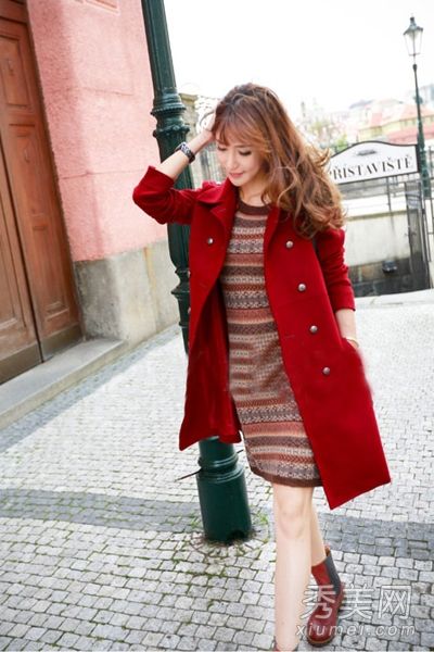 深秋的时候，穿着一件连衣裙里面套着一件薄呢子大衣的女士。